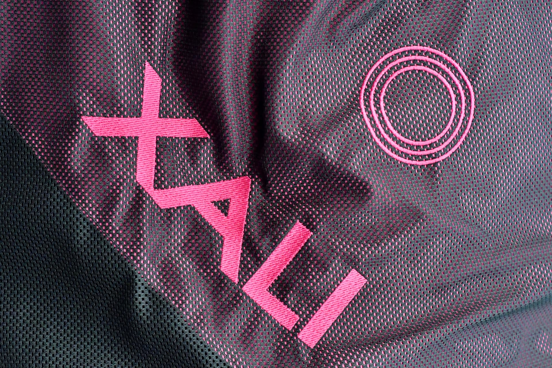 Close-up of the XALI ProSeries blanket textile with embroidered magenta logo
